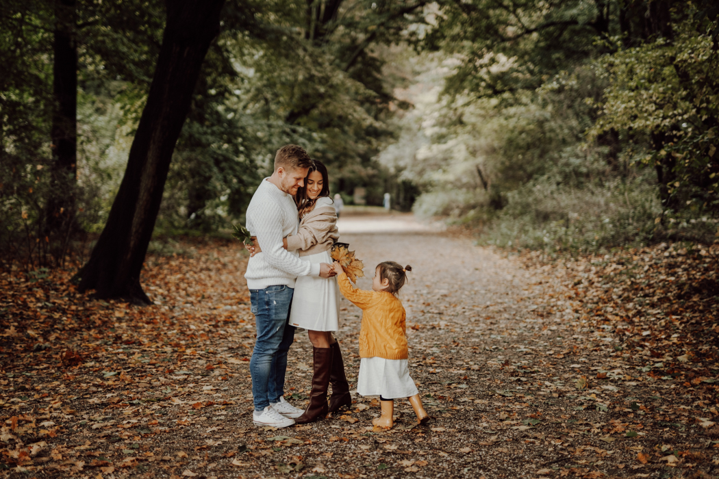 jesienna sesja rodzinna w Parku Skaryszewskim w Warszawie przytulacjący się rodzice i dziecko