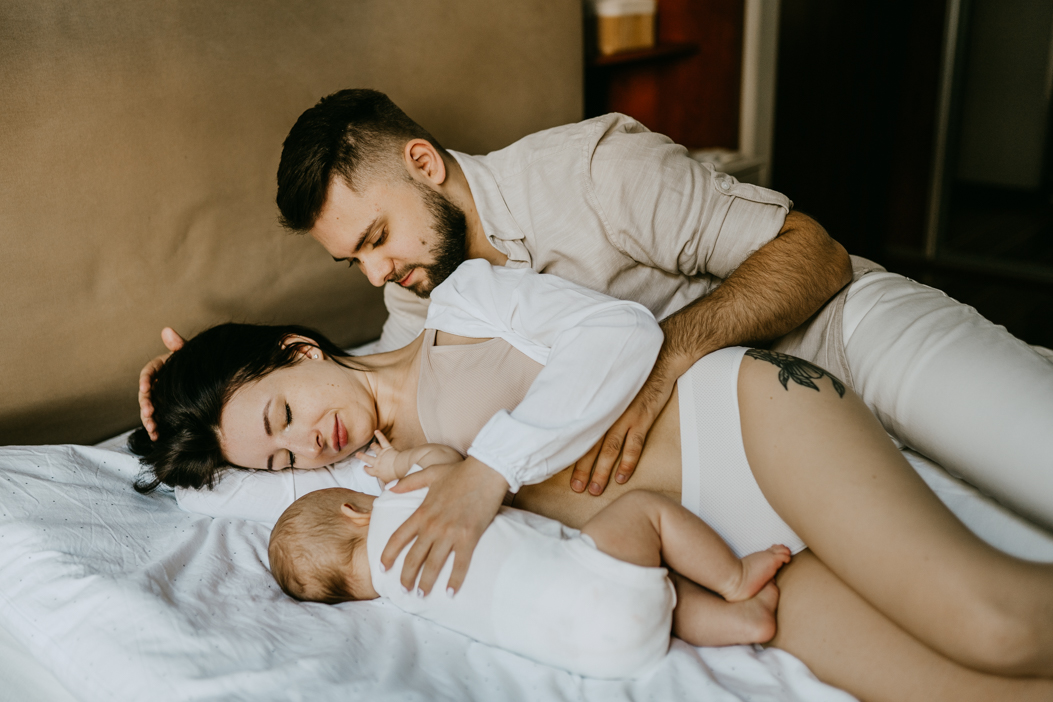 rodzinne zdjęcie w białej pościeli wykonane podczas naturalnej sesji niemowlęcej w mieszkaniu w Warszawie 