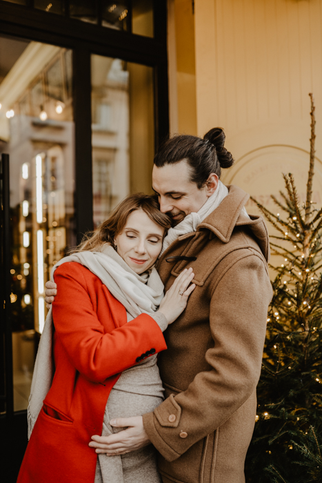 delikatna blondynka przytulająca się do swojego mężczyny podczas zimowej sesji ciążowej w Warszawie