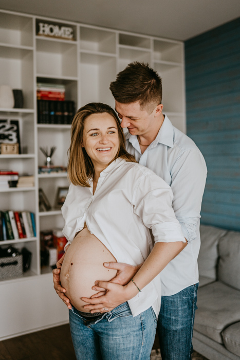 fotografia ciążowa szczęśliwej pary przyszłych rodziców wykonana na domowej sesji fotograficznej