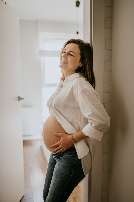 fotografia ciążowa kobiety wykonana podczas sesji zdjęciowej w domu w Warszawie