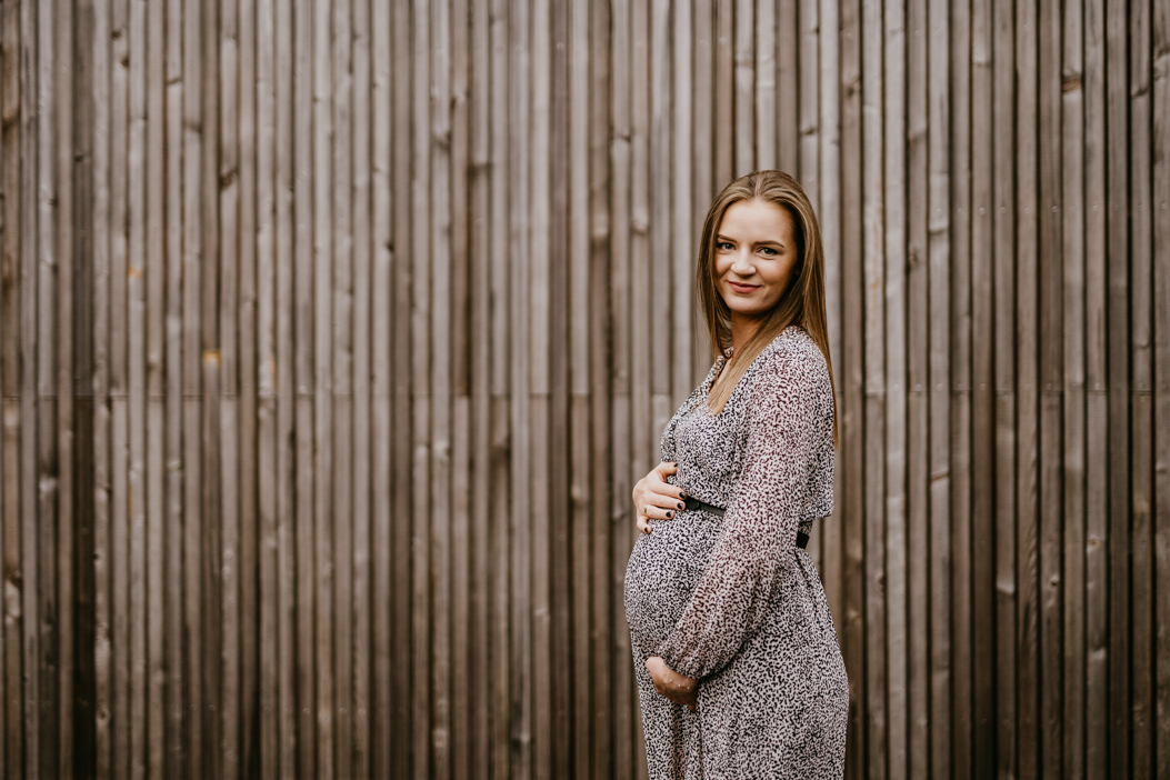 śliczna młoda kobieta w ciąży pozująca fotografowi do zdjęcia na sesji ciążowej w Warszawie