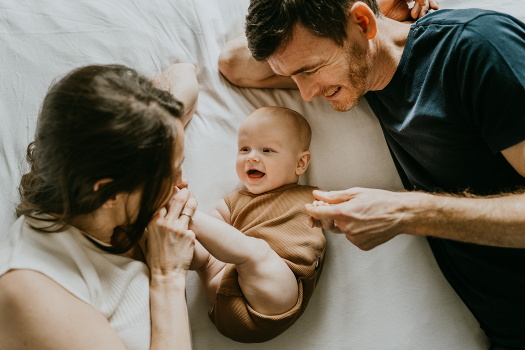zdjęcie śmiejącego się niemowlaka na rodzinnej sesji wykonane przez fotografa z warszawy