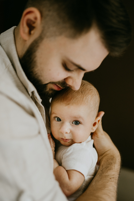 piękny portret taty ze słodkim niemowlakiem wykonany przez fotografa z Warszawy
