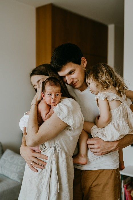 rodzinne zdjęcie z noworodkiem zrobione podczas naturalnej domowej sesji lifestyle w warszawie