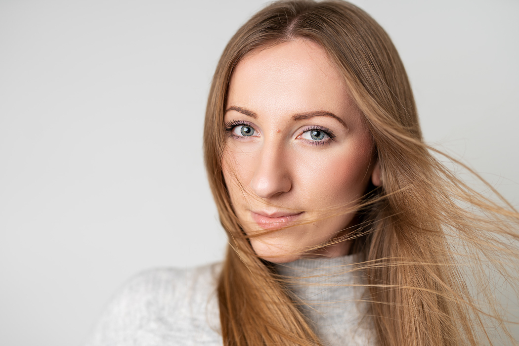 młoda kobieta z rozwianymi włosami patrząca w obiektyw aparatu podczas portretowej sesji zdjęciowej w Warszawie