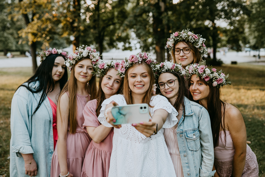 dziewczyny w kolorowych sukienkach i wiankach z żywych kwiatów  pozujące do selfie na wieczorze Panieńskim w Warszawie