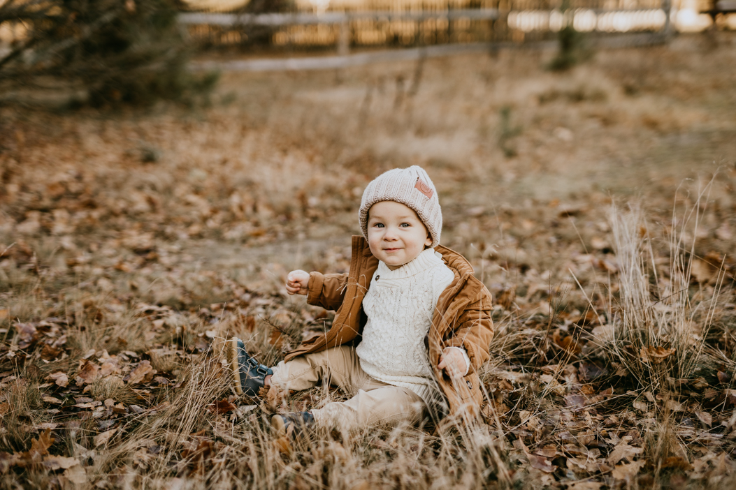 jesienna fotografia rocznego chłopca ubranego w beżowe i karmowe ubrania