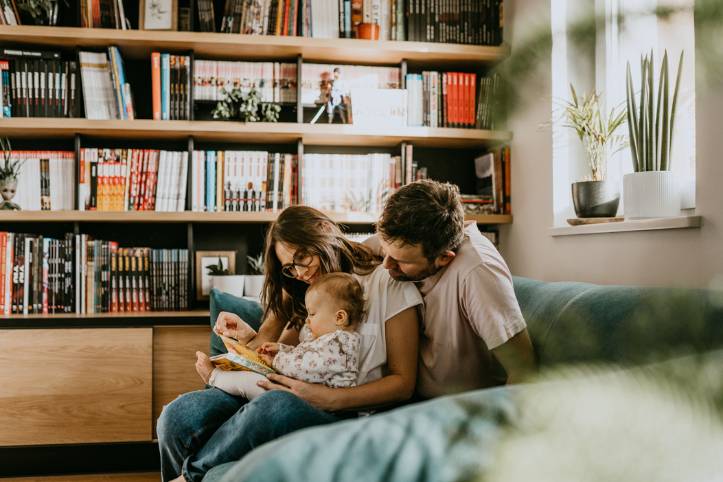 rodzice czytający książeczke dziecku podczas sesji rodzinnej typu lifestyle