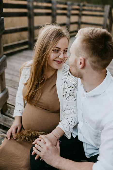 romantyczne zdjęcie kobiety patrzącej na partnera podczas sesji ciążowej