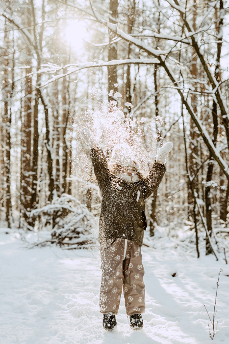 fotografia dziecka podrzucającego śnieg podczas sesji zdjęciowej