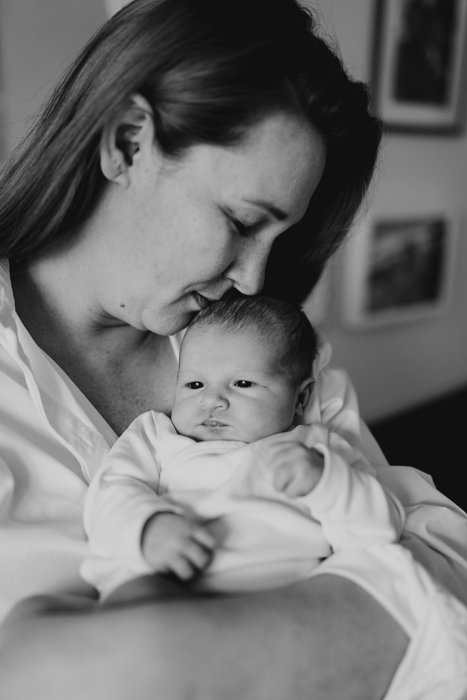 czarno-białe zdjęcie mamy trzymającej na rękach nowonarodzoną córeczkę
